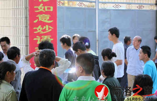 家們送考生進入考場時，一縷光環(huán)閃現(xiàn)鏡頭中，這也許就是人們的理想與期待.jpg