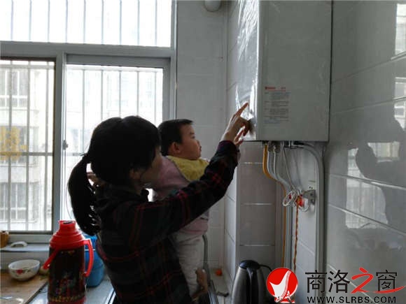 家住市區(qū)香菊小區(qū)的李女士正在操作自家剛剛安裝的燃氣壁掛爐，提升室內(nèi)的溫度。