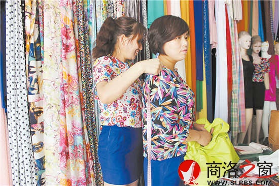 雷小莉仔細地為客人量尺寸，量體裁衣是裁縫鋪最大的優(yōu)勢。